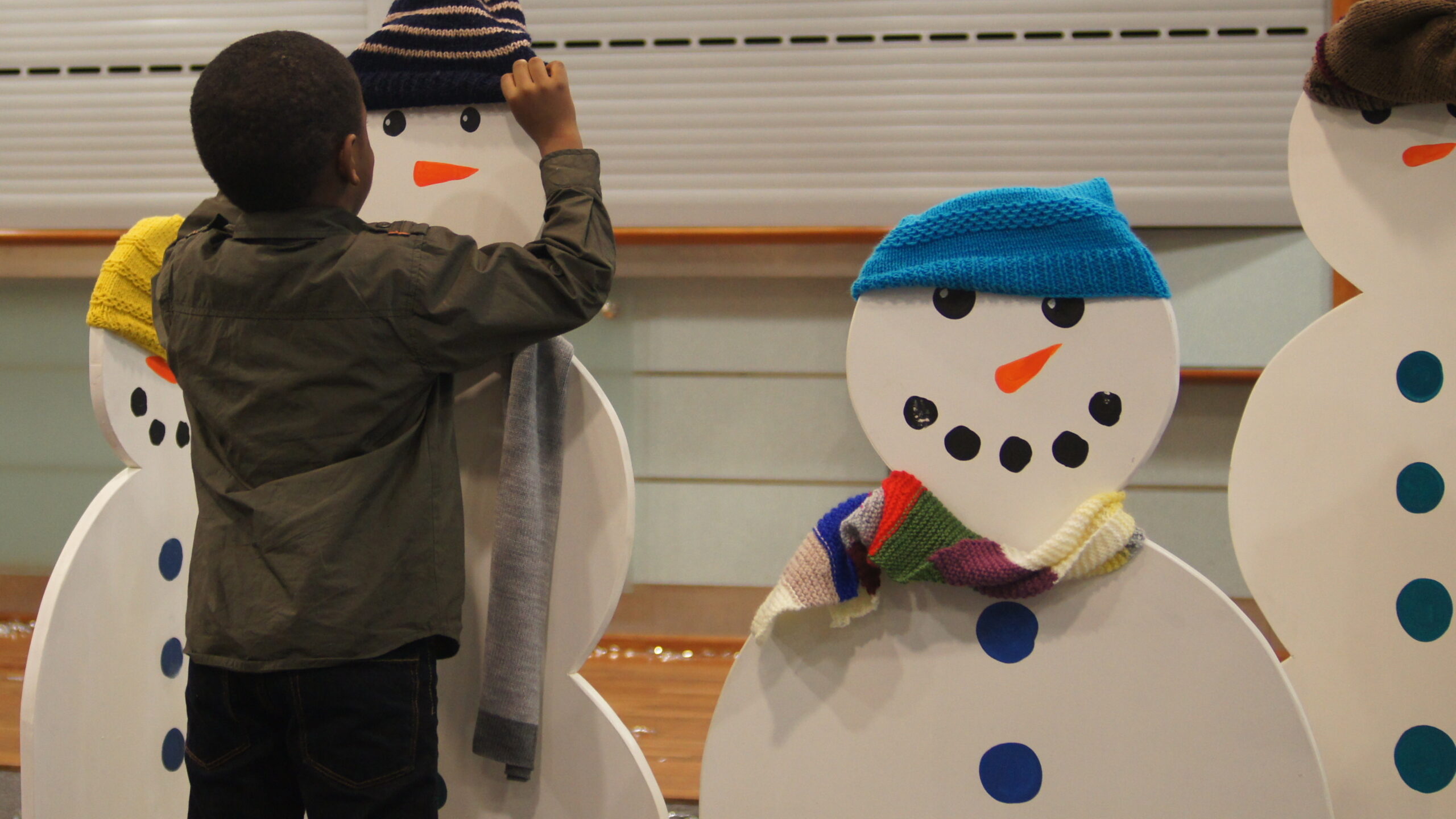 Child decorating a snowman