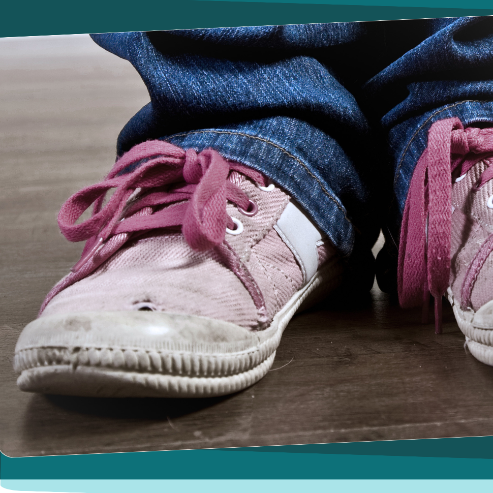 Image shows a pair of children's pink shoes that show signs of wear.