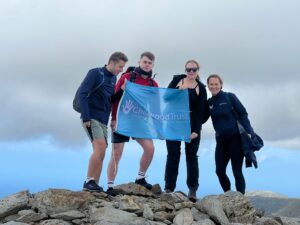 Mountain climbers with a The Childhood Trust flag