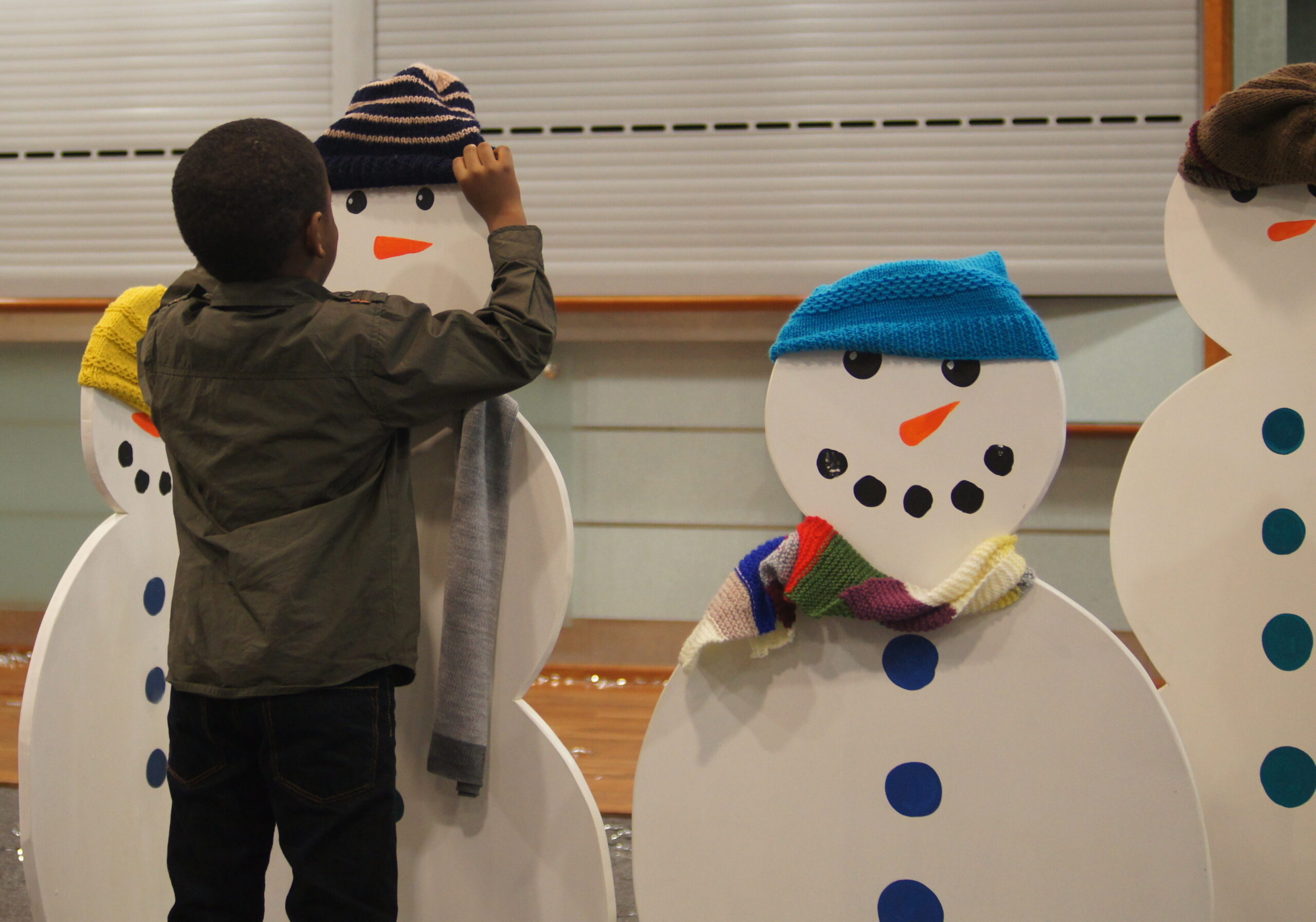 Child decorating a snowman